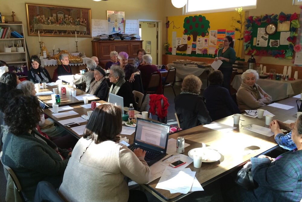 Adults gathered around tables in a church classroom.