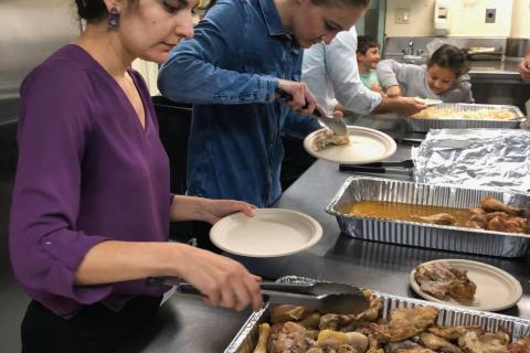 Parish volunteers portion meals in the kitchen during a past Winter Shelter service.